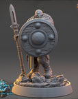 A detailed 3D model of a warrior figure holding a shield and spear, standing on a rocky base.