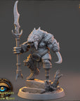 A detailed 3D model of a fantasy creature, possibly a dragon or serpent, holding a staff and standing on a rock formation. The creature has a fierce expression and is surrounded by various weapons and armor.