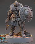 A detailed 3D model of a warrior figure, wearing a helmet and armor, holding a shield and sword. The figure is standing on a rocky base and appears to be ready for battle.