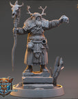 A detailed 3D model of a fantasy character, likely a deity or magical being, standing on a pedestal and holding a staff with a skull and crossbones symbol on it. The character is wearing a long robe and has antlers on their head.