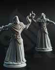 two statues of a person in a long robe, one holding a staff and the other a scroll, set against a dark background.